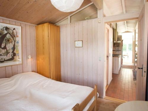 MosebølleにあるThree-Bedroom Holiday home in Faxeのベッドルーム1室(ベッド1台付)、廊下が備わります。