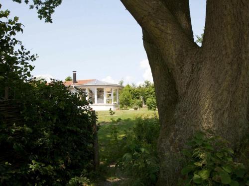 a white house with a tree in front of it at Seaside Escape in Praesto - By Traum Ferienwohnungen in Mosebølle
