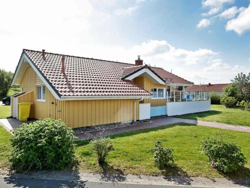 a yellow house with a large yard at 6 person holiday home in Otterndorf in Otterndorf