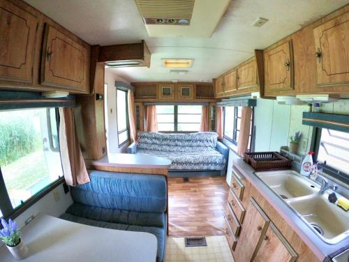 an interior of an rv with a sink and a couch at Honey Tiny Home in Vadu Crişului