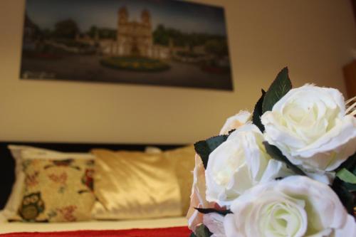 a bouquet of white roses sitting on a bed at Turismo Homes Solar Do Areal in Braga