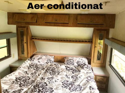 a bed in an rv with a sign above it at Honey Tiny Home in Vadu Crişului