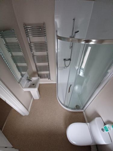 uma casa de banho com um chuveiro, um WC e um lavatório. em The Westby em Bournemouth