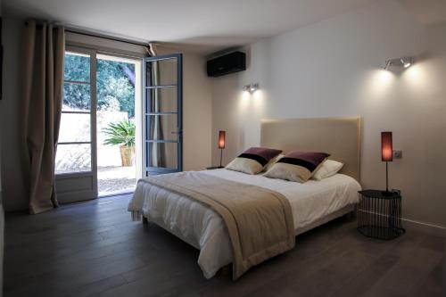 - une chambre avec un grand lit et une porte coulissante en verre dans l'établissement Magnifique Villa avec piscine à débordement à Maussane les Alpilles, à Maussane-les-Alpilles