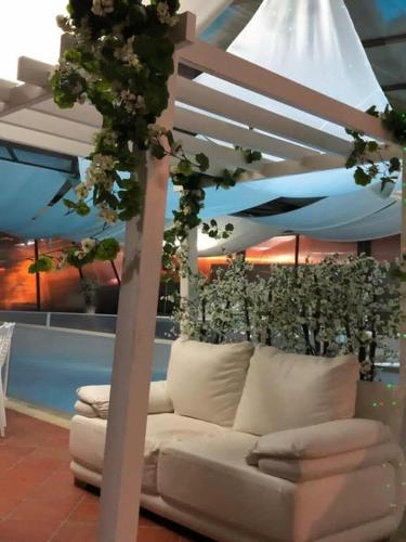 a white couch sitting in a room with flowers at Turismo Homes Solar Do Areal in Braga