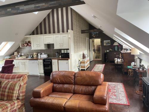 a living room with a couch and a kitchen at Tides Apartments Liscannor in Liscannor