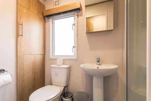 a small bathroom with a toilet and a sink at Yorkshire Lodge with Hot Tub in York