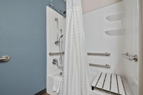 a bathroom with a shower with a white shower curtain at Extended Stay America Suites - Miami - Airport - Blue Lagoon in Miami