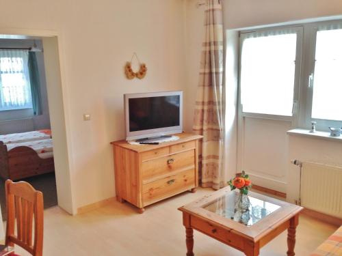 a living room with a television on a wooden dresser at Reethäuser auf Rügen in Middelhagen