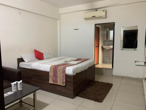 a bedroom with a bed and a bathroom with a sink at JK Rooms 147 Lions - Koradi Nagpur in Nagpur
