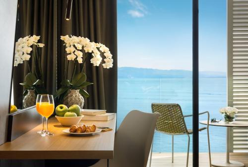 a dining room with a table with a glass of wine at Hotel Istra - Liburnia in Opatija