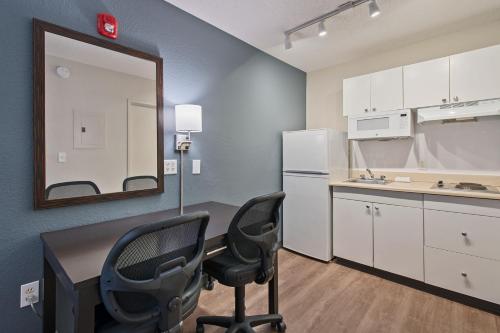 a kitchen with two chairs and a desk and a mirror at Extended Stay America Suites - Miami - Airport - Blue Lagoon in Miami
