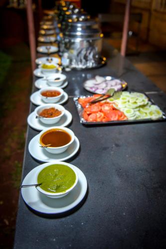 a long table with a row of plates of food at Adamo The Village in Matheran