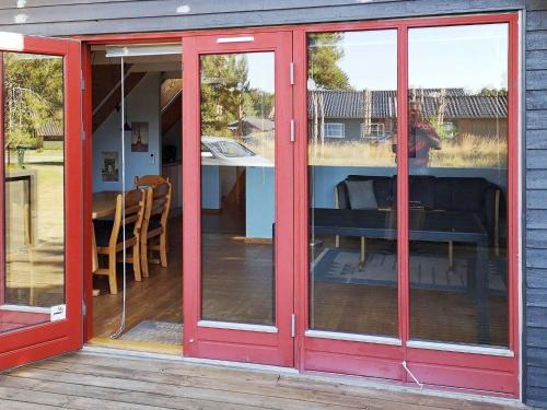 ロービュにある6 person holiday home in R dbyの家屋の赤いガラスの引き戸(パティオ付)