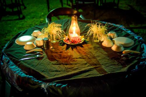 a table with a vase and other items on it at Adamo The Village in Matheran