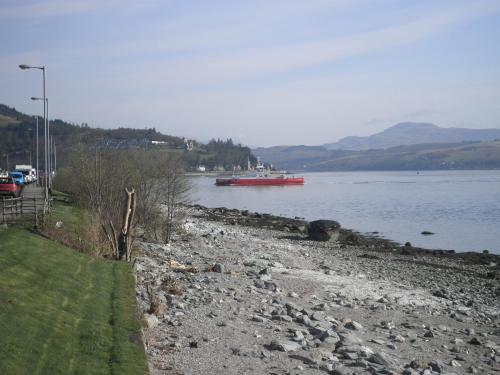 a river with a red boat in the water at Douglas Park Guest House in Dunoon