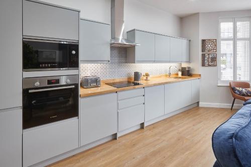 a kitchen with white cabinets and black appliances at Host & Stay - Green View in Harrogate