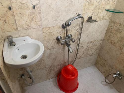 a bathroom with a sink and a red fire hydrant at JK Rooms 147 Lions - Koradi Nagpur in Nagpur