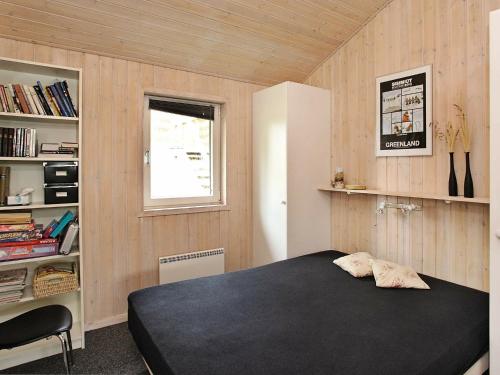 a bedroom with a black bed and a window at Seaside Haven Retreat - By Traum Ferienwohnungen in Skram