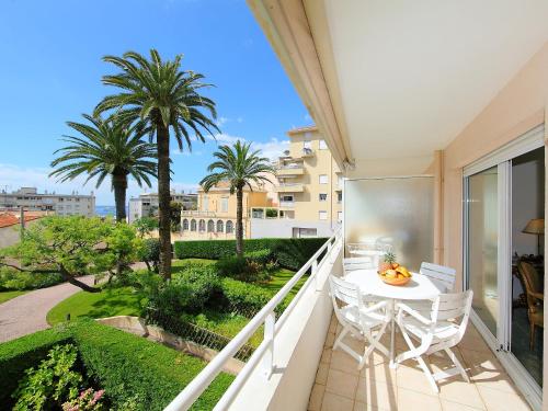 un balcon avec une table, des chaises et des palmiers dans l'établissement Apartment Riviera Park-1 by Interhome, à Cannes