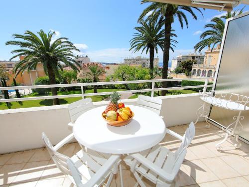 - une table et des chaises blanches sur un balcon avec un bol de fruits dans l'établissement Apartment Riviera Park-1 by Interhome, à Cannes