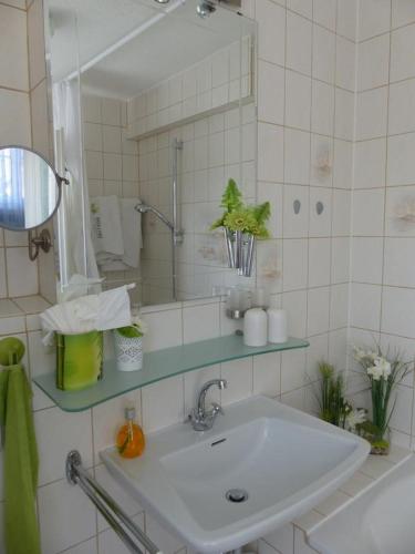 a white bathroom with a sink and a mirror at Haus Marija M in Badenweiler