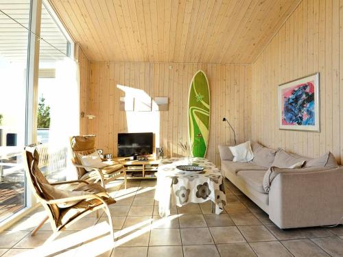 a living room with a couch and a table and a surfboard at 8 person holiday home in Fan in Fanø