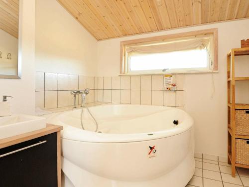 a white bath tub in a bathroom with a window at 8 person holiday home in Fan in Fanø