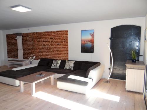 a living room with a couch and a brick wall at Speicher Residenz Barth E4 App 9 in Barth