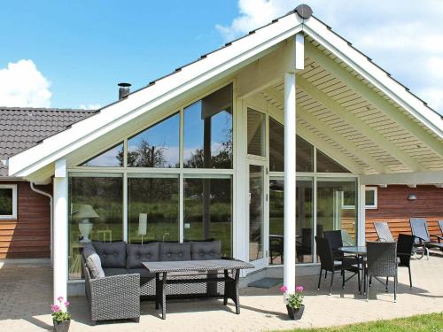 a large glass house with a table and chairs at 14 person holiday home in Idestrup in Marielyst