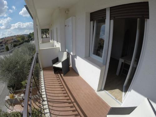 a balcony of a house with a chair at Appartamento Corallo in Porto Recanati