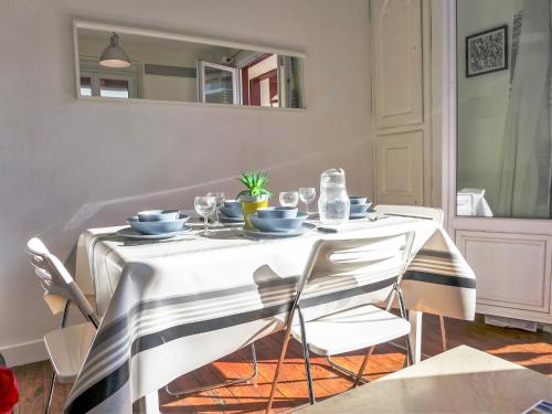 a dining room table with a white and black table cloth at Apartment Goélands by Interhome in Biarritz