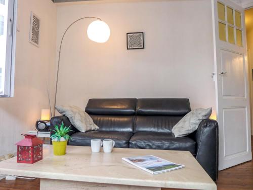 sala de estar con sofá de cuero y mesa en Apartment Goélands by Interhome, en Biarritz