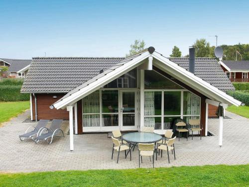 a pavilion with a table and chairs in front of a house at 8 person holiday home in Juelsminde in Sønderby