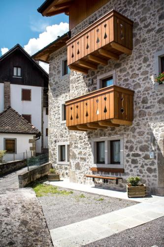 a building with wooden balconies on the side of it at Apartment Casa Rasat-1 by Interhome in Ovasta