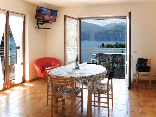 una sala da pranzo con tavolo, sedie e vista di Apartment Belvedere-2 by Interhome a Malcesine