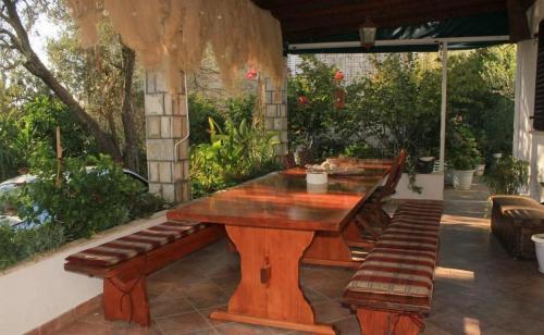 une table en bois et des bancs sur une terrasse dans l'établissement Villa Ro-Ela, à Trsteno