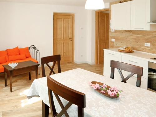 una cucina e un soggiorno con tavolo e sedie di Apartment Cjase da Maestre-2 by Interhome a Raveo