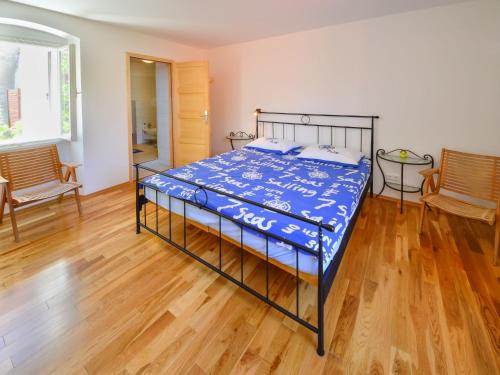 a bed in a room with a wooden floor at Holiday Home Dubravka by Interhome in Osor