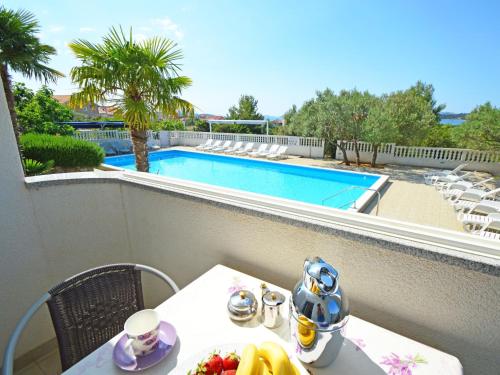 - une table avec un bol de fruits sur un balcon avec une piscine dans l'établissement Apartment Rina-4 by Interhome, à Vodice