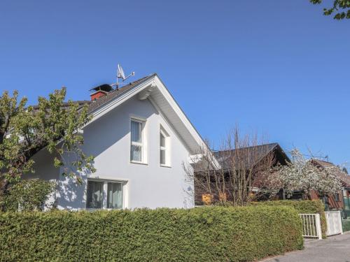 a white house with a hedge in front of it at Holiday Home Seehaus Blue Faak by Interhome in Faak am See