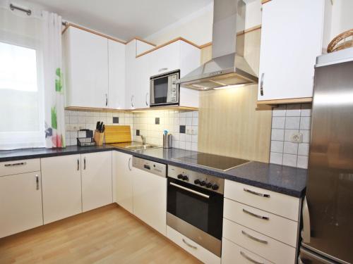 a kitchen with white cabinets and black counter tops at Holiday Home Seehaus Blue Faak by Interhome in Faak am See