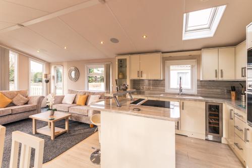 an open kitchen and living room with a couch at Juniper Lodge with Hot Tub in York