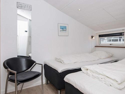 a room with two beds and a chair in it at 2 person holiday home in Vejers Strand-By Traum in Vejers Strand