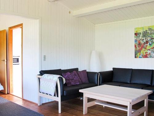 a living room with a couch and a coffee table at 6 person holiday home in Str by in Strøby