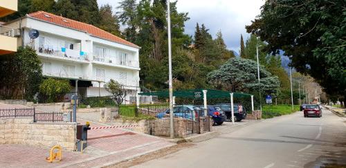 a building with cars parked on the side of a street at Apartmani Galiot in Igalo