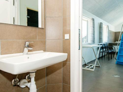 a bathroom with a sink and a room with a table at 20 person holiday home in Nørre Nebel in Nørre Nebel