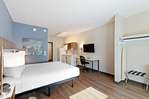 a hotel room with a white bed and a desk at Extended Stay America Premier Suites - Tampa - Fairgrounds - Casino in Tampa
