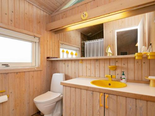 ein Badezimmer mit Waschbecken, Toilette und Spiegel in der Unterkunft Seaside Serenity in Blokhus-By Traum in Blokhus