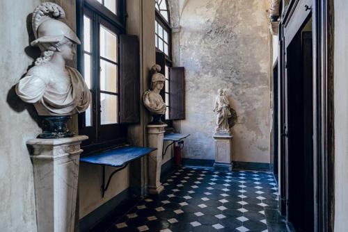 un couloir avec une statue d'une femme sur le mur dans l'établissement La Foresteria di Palazzo Picedi Benettini, à Sarzana